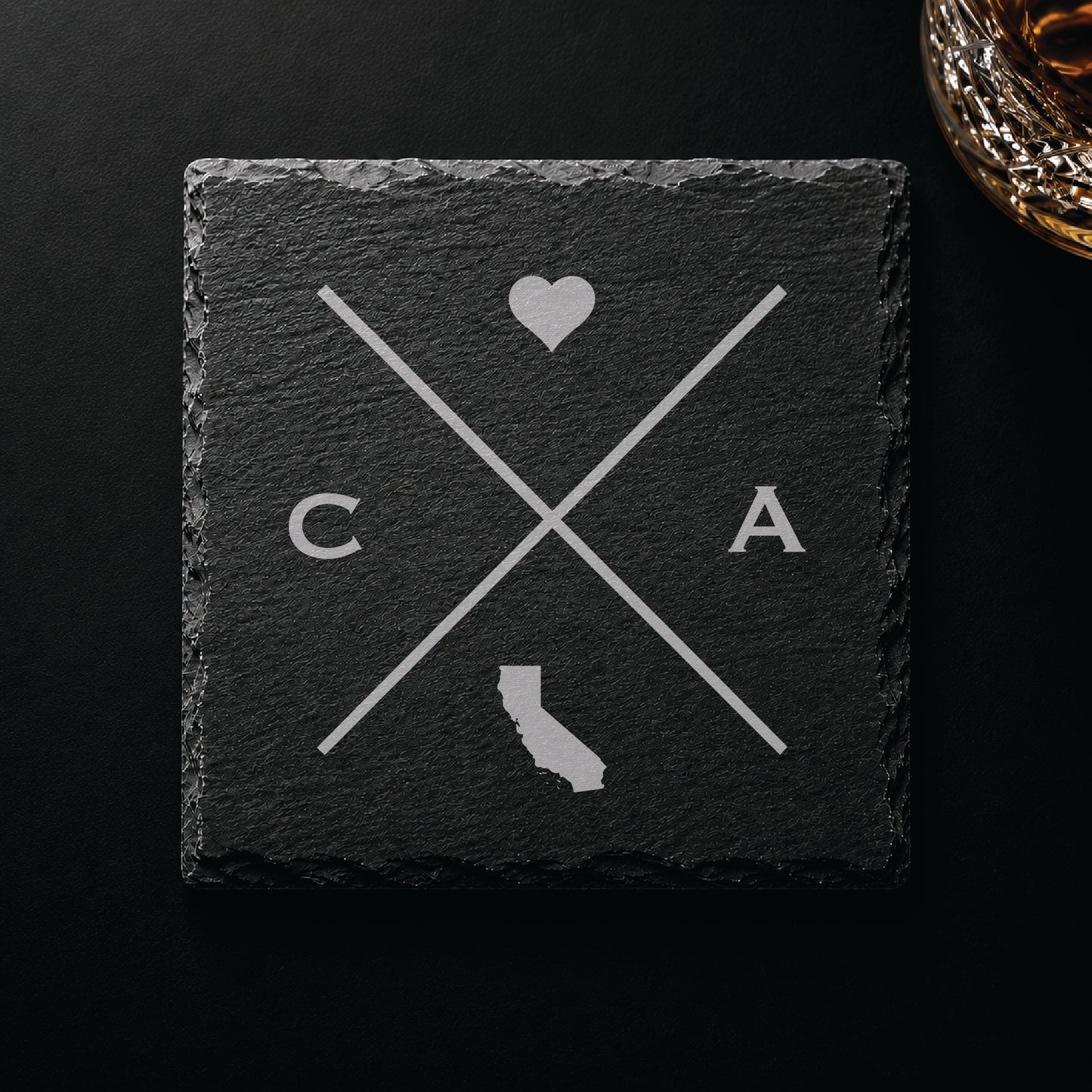 Engraved California slate coaster featuring a minimalist crossed-line design with heart detail and California silhouette on a clean light background.