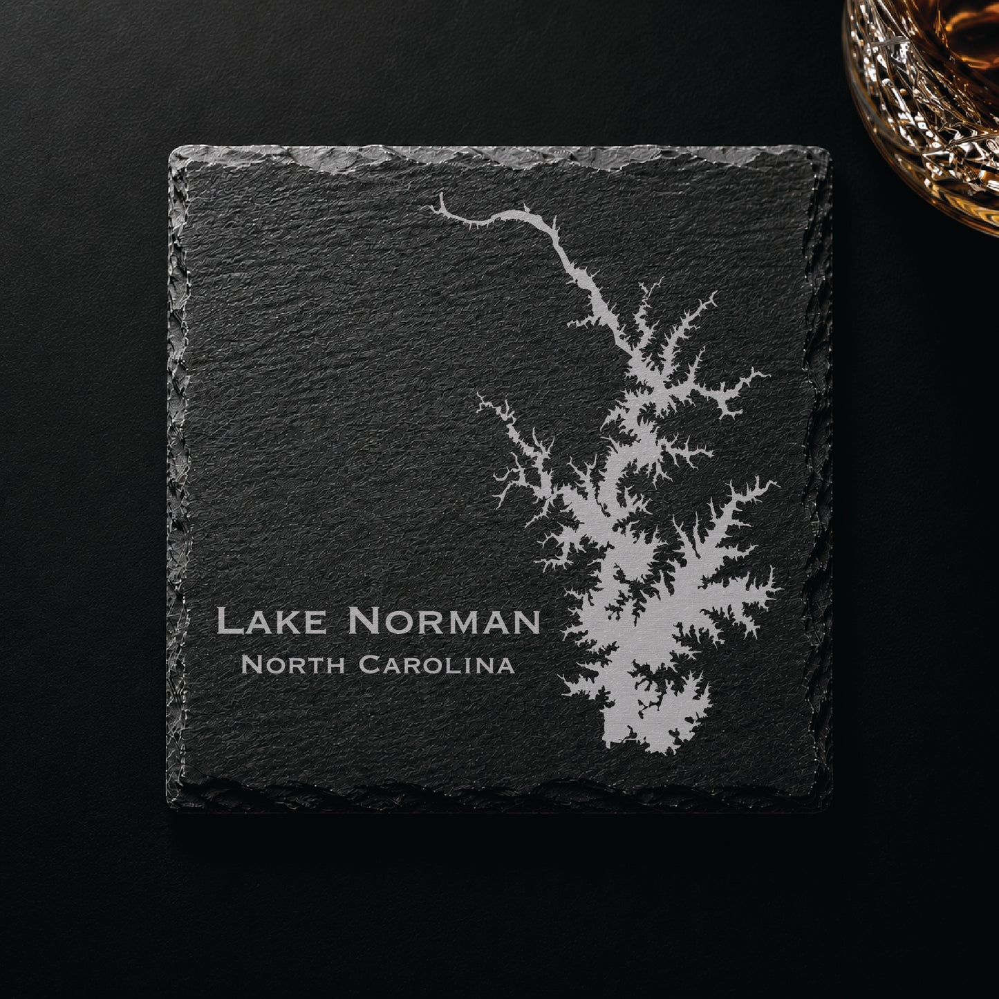 Dark slate coaster engraved with a detailed Lake Norman map and North Carolina text on a dark background.