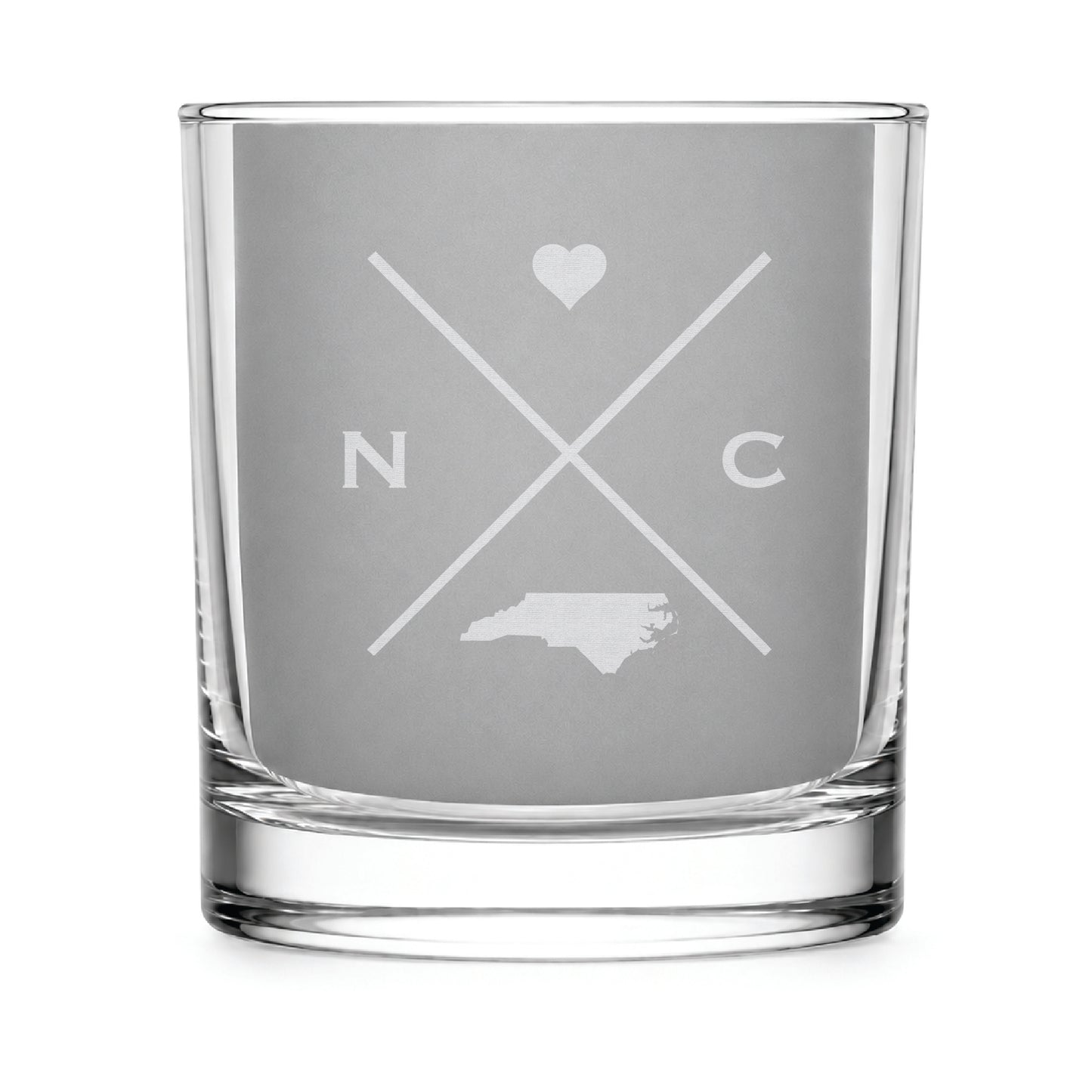 Clear engraved rocks glass featuring a minimalist crossed-line North Carolina design with monogram initials, heart icon, and North Carolina silhouette on a clean light background.