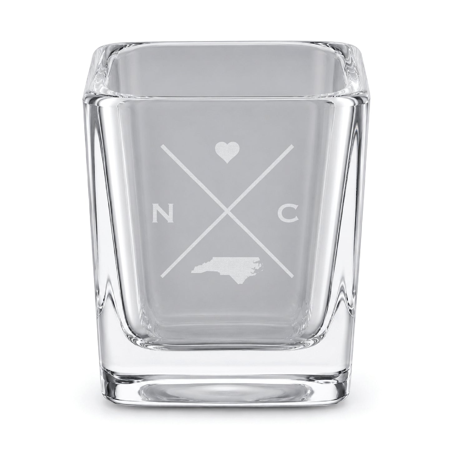 Clear engraved North Carolina shot glass featuring a minimalist crossed-line design with heart detail and North Carolina silhouette on a clean light background.