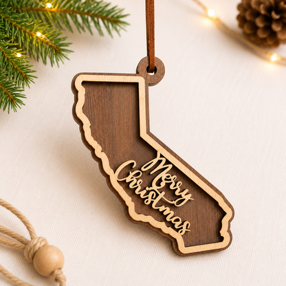 Wooden ornament shaped like a state with 'Merry Christmas' text, surrounded by Christmas decor on a light background.
