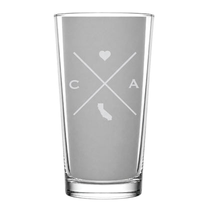 Clear pint glass with engraved California crossed-line design, heart icon, and California silhouette on a clean light background.