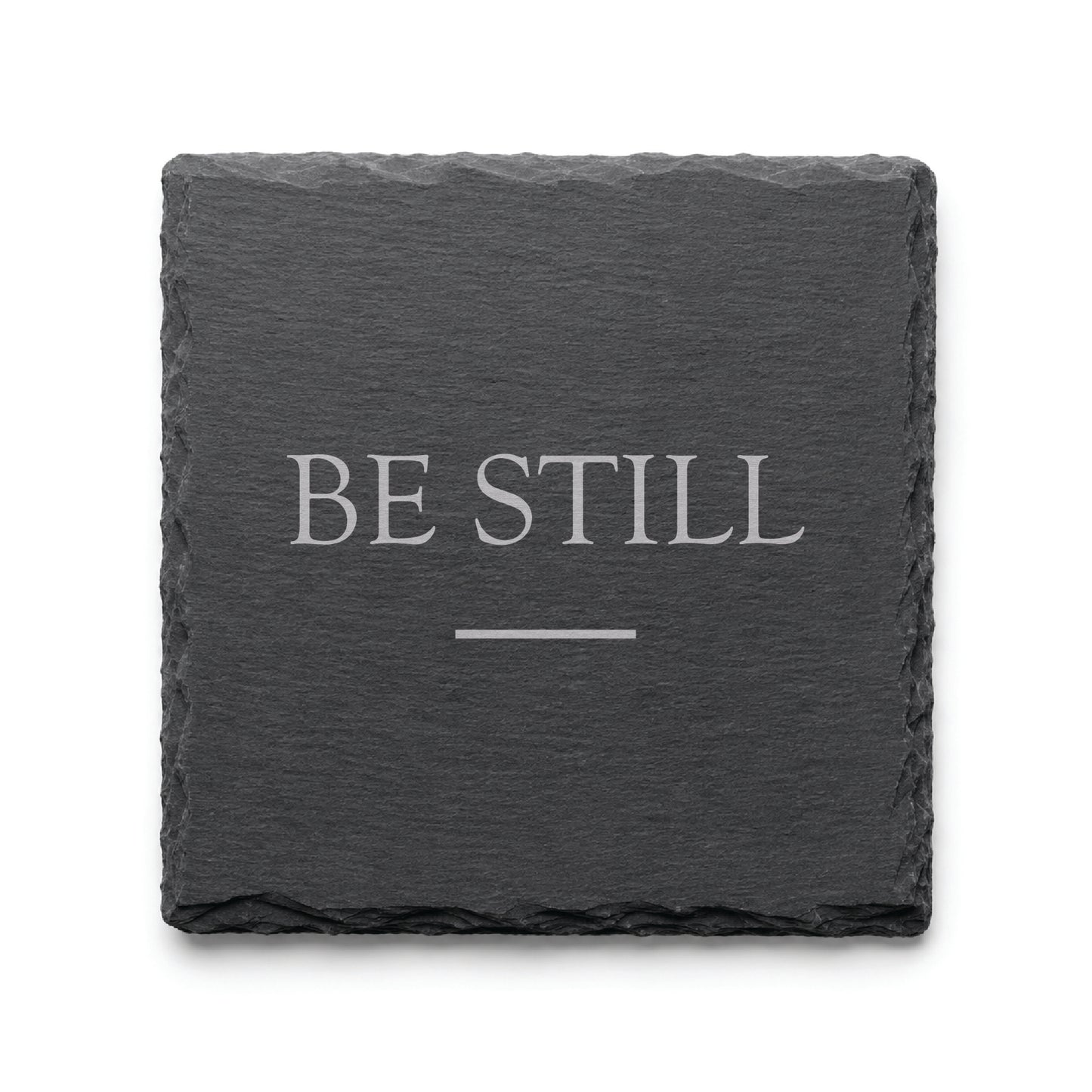 Black slate coaster engraved with the inspirational phrase Be Still and a minimalist accent line.