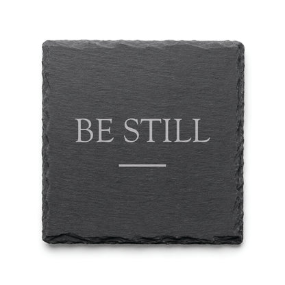 Black slate coaster engraved with the inspirational phrase Be Still and a minimalist accent line.