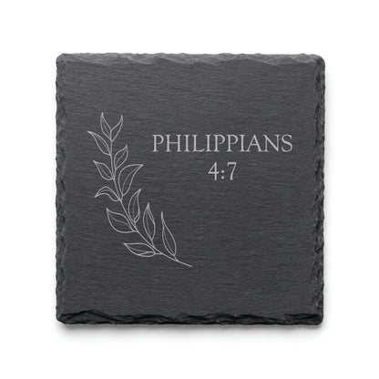 Black slate coaster engraved with Philippians 4:7 alongside a delicate botanical leaf illustration.