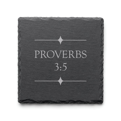 Black slate coaster engraved with Proverbs 3:5 and decorative starburst divider elements.