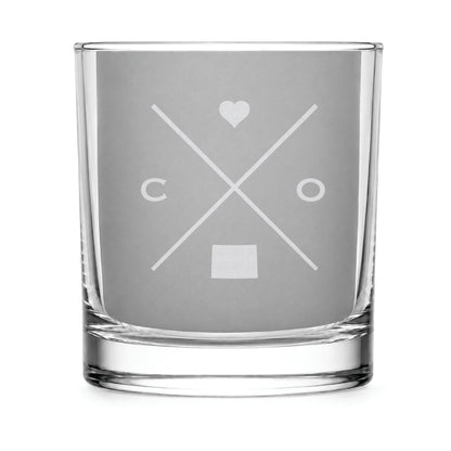 Clear engraved rocks glass featuring a minimalist crossed-line Colorado design with monogram initials, heart icon, and Colorado silhouette on a clean light background.