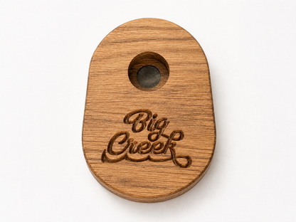 Wooden whiskey smoker with custom “Big Creek” engraved logo, round shape with center burn chamber and mesh screen.