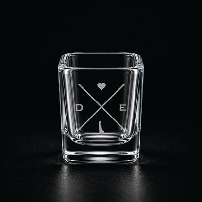 Engraved Delaware shot glass with modern crossed-line state design and frosted laser engraving on a dark background.