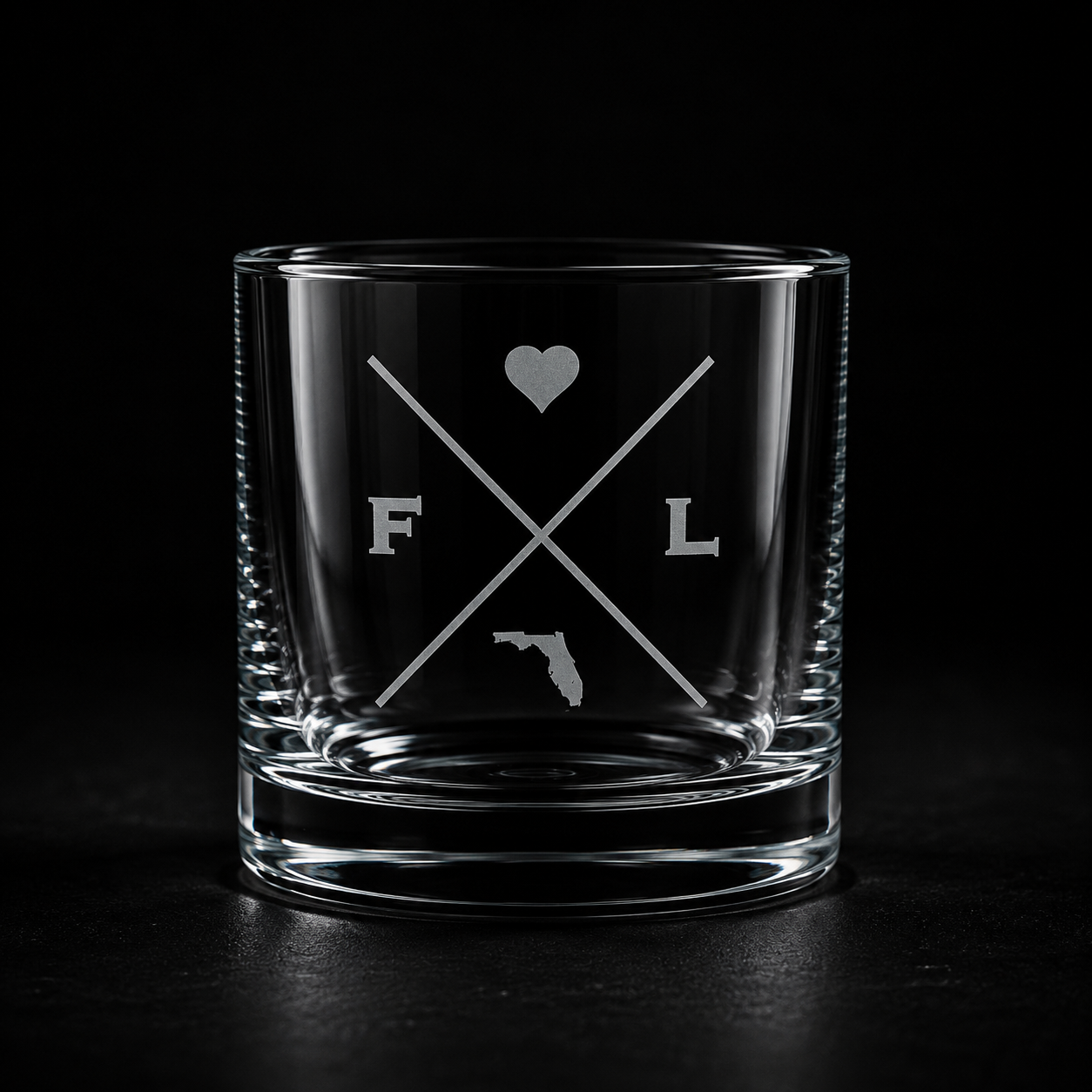 Engraved Florida rocks glass with frosted Florida silhouette and crossed-letter monogram on a dark background.