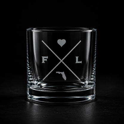 Engraved Florida rocks glass with frosted Florida silhouette and crossed-letter monogram on a dark background.