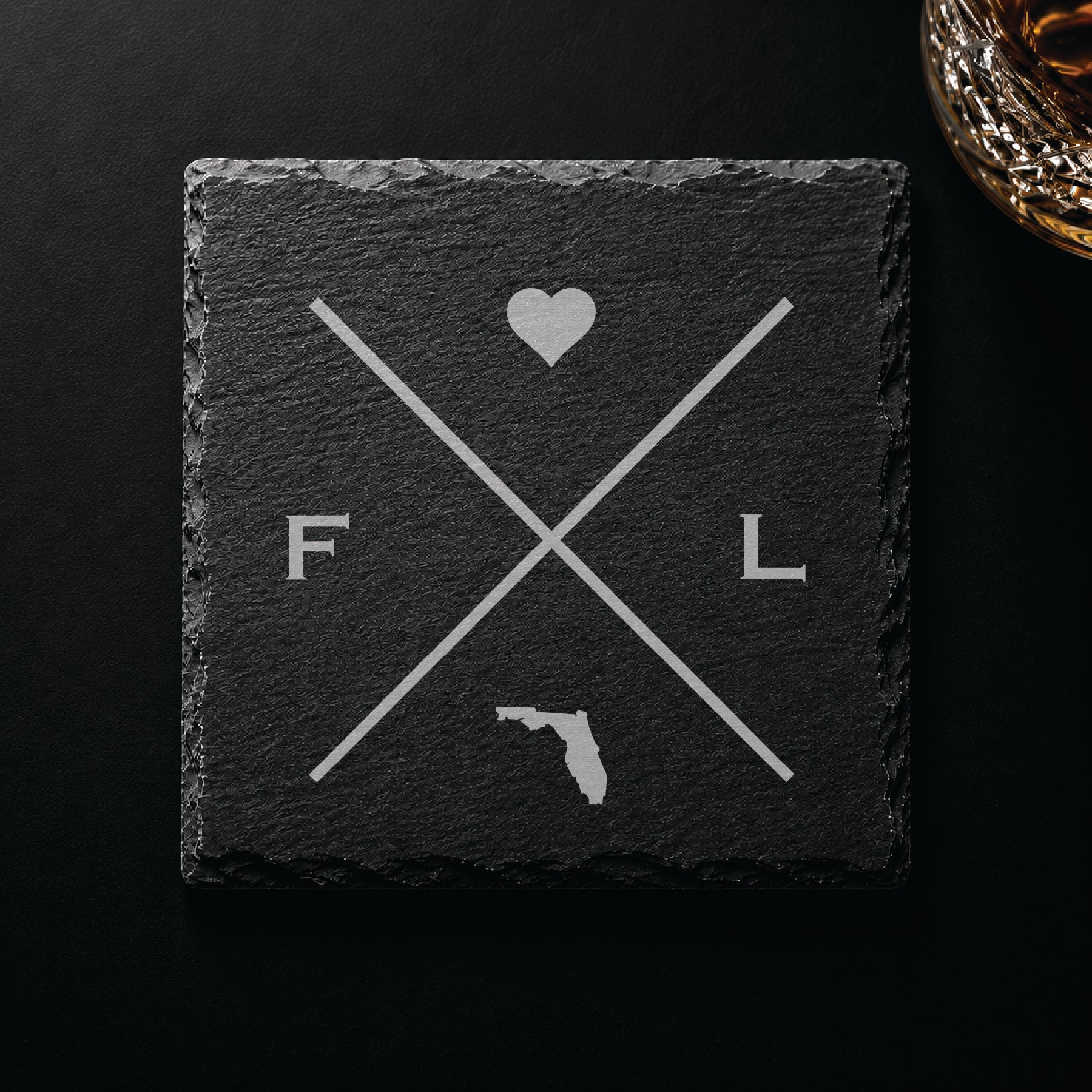 Dark slate coaster with engraved Florida crossed-line design, heart icon, and Florida silhouette on a dark background.