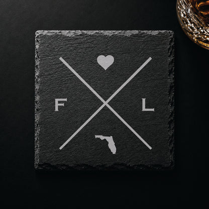Dark slate coaster with engraved Florida crossed-line design, heart icon, and Florida silhouette on a dark background.