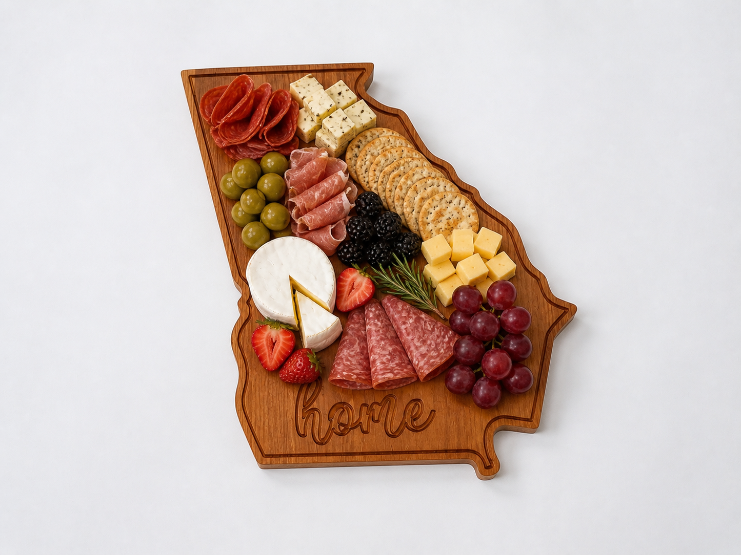 Georgia shaped wooden serving board styled with charcuterie including cheese, meats, nuts, and fruit