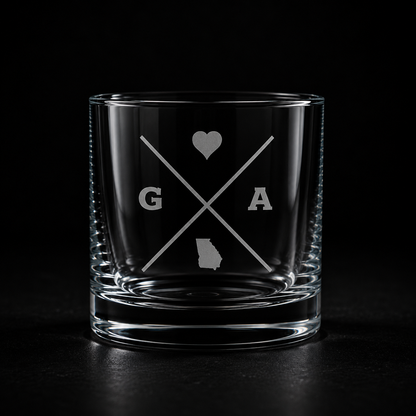 Engraved Georgia rocks glass with frosted Georgia silhouette and crossed-letter monogram on a dark background.