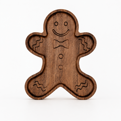 Gingerbread-shaped snack tray standing upright on a light neutral background, featuring engraved facial details and recessed compartments with smooth carved edges.