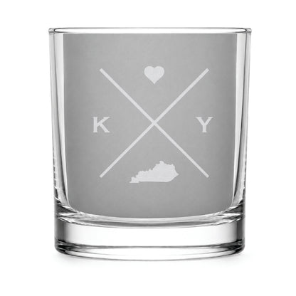 Clear engraved rocks glass featuring a minimalist crossed-line Kentucky design with monogram initials, heart icon, and Kentucky silhouette on a clean light background.