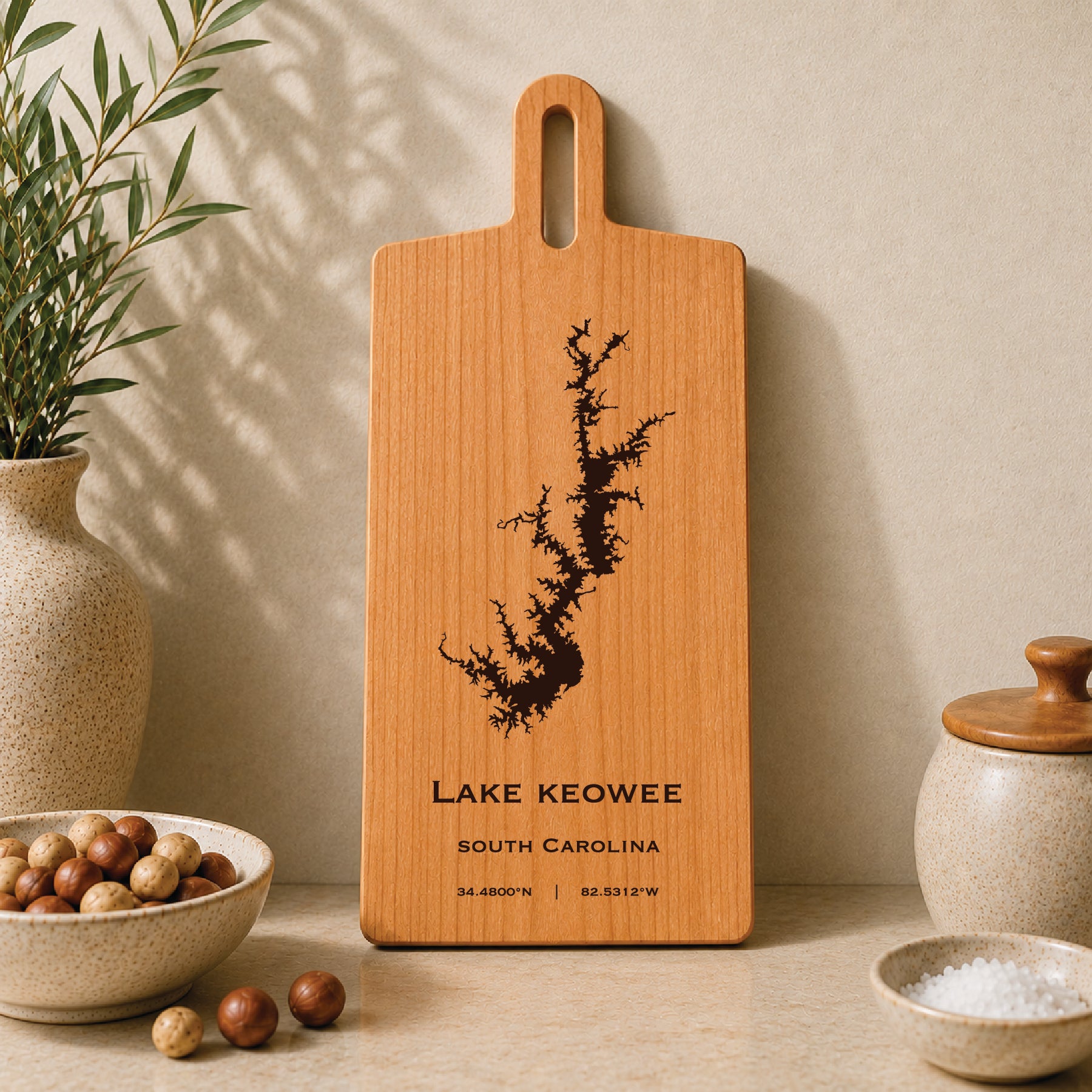 Lake Keowee engraved serving board displayed on a neutral kitchen countertop with ceramic decor
