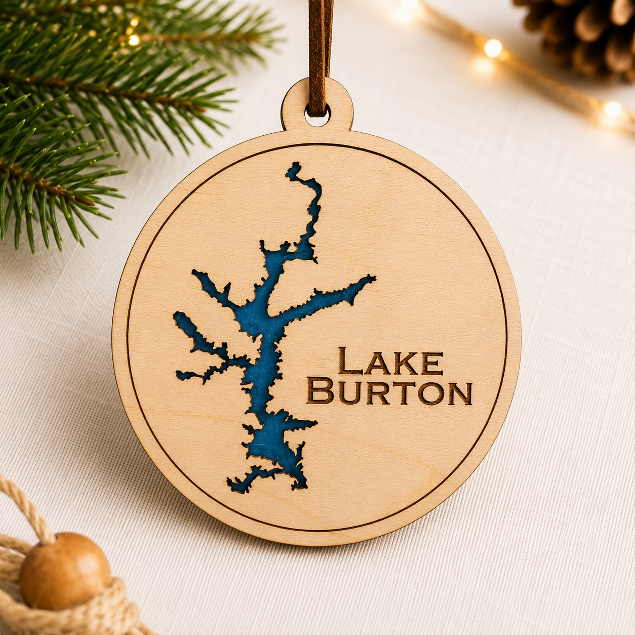 Close-up angled view of layered wood Lake Burton ornament showing dimensional lake design and engraved lettering.