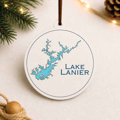 White Lake Lanier ornament with blue lake map design on a warm holiday linen background with greenery and lights.