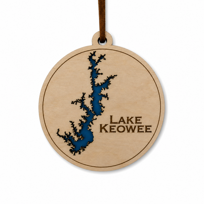 Layered wood Lake Keowee ornament with blue lake detail and brown hanging cord on a clean light background.