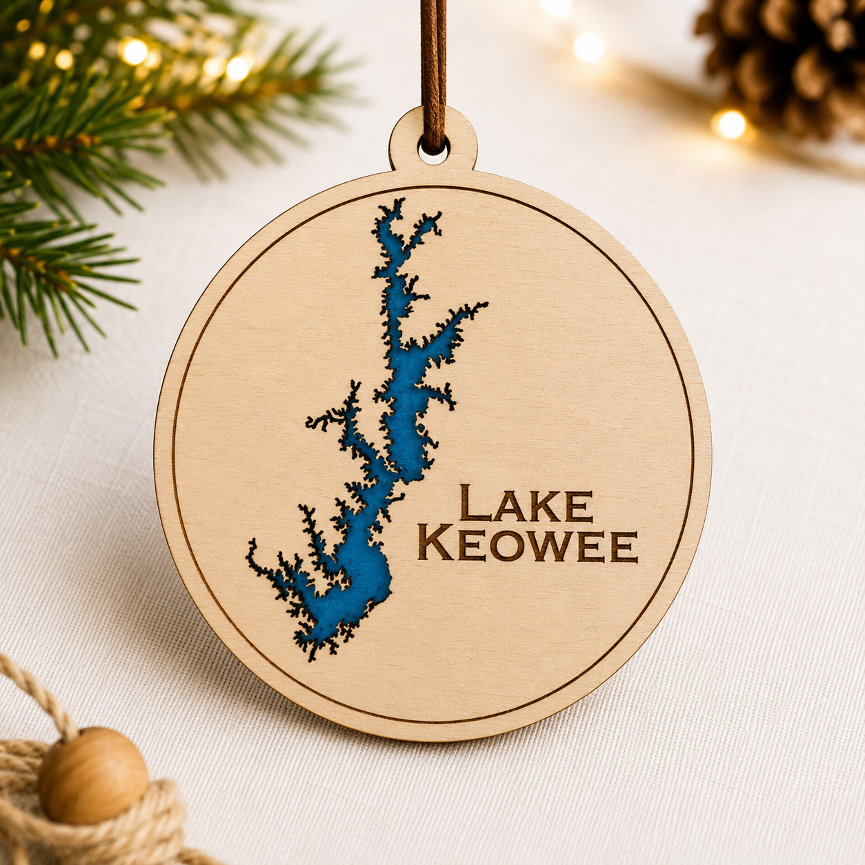 Close-up angled view of layered wood Lake Keowee ornament showing dimensional lake design and engraved lettering.