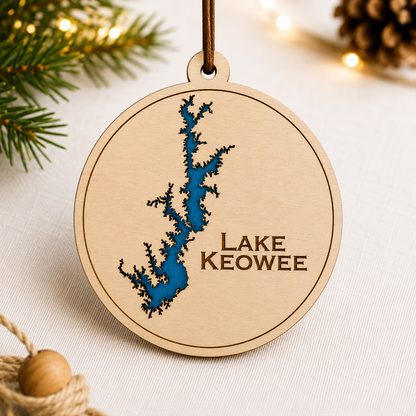 Close-up angled view of layered wood Lake Keowee ornament showing dimensional lake design and engraved lettering.