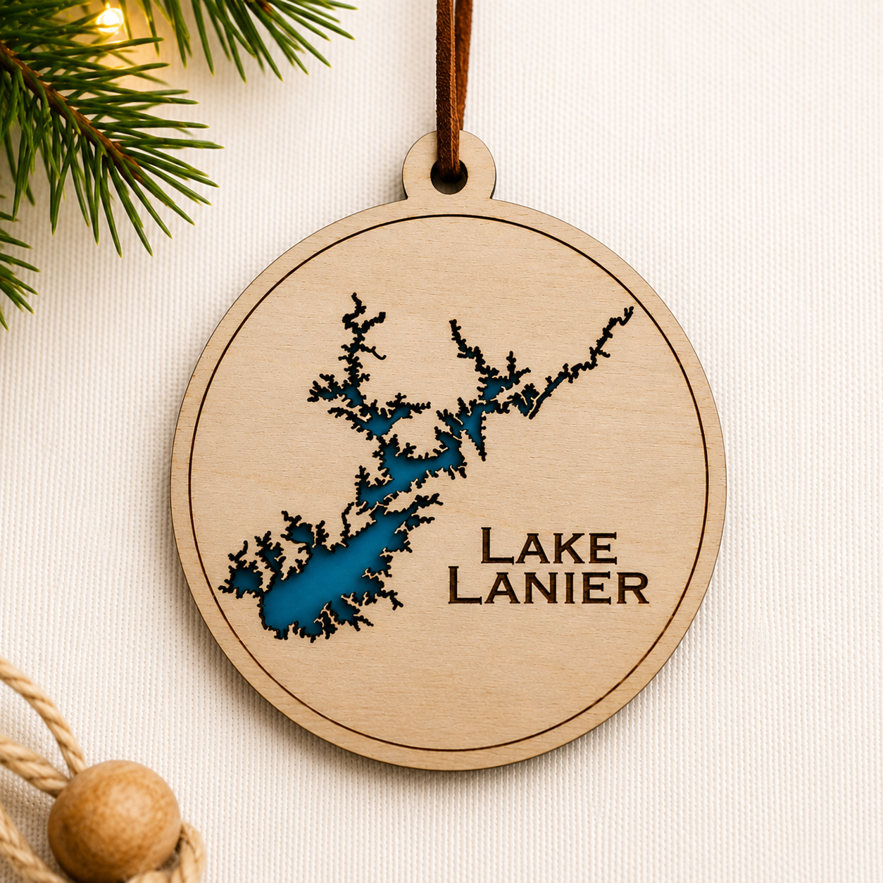 Close-up angled view of layered wood Lake Lanier ornament showing dimensional lake design and engraved lettering.
