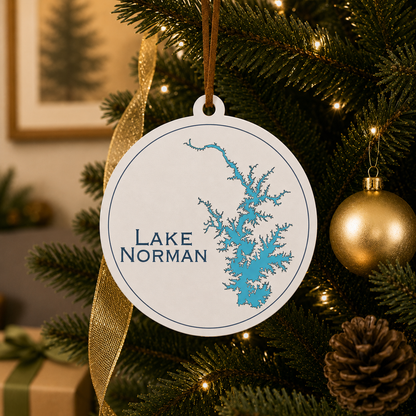 White Lake Norman ornament hanging on a decorated Christmas tree with warm lights and gold ribbon.