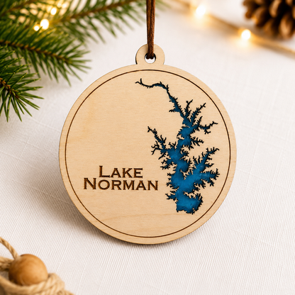 Close-up angled view of layered wood Lake Norman ornament showing dimensional lake design and engraved lettering.