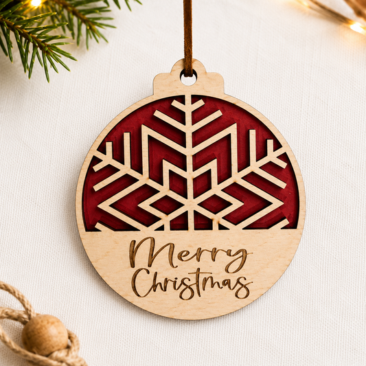 Layered wooden snowflake Christmas ornament with red backing and engraved Merry Christmas text styled on neutral fabric background