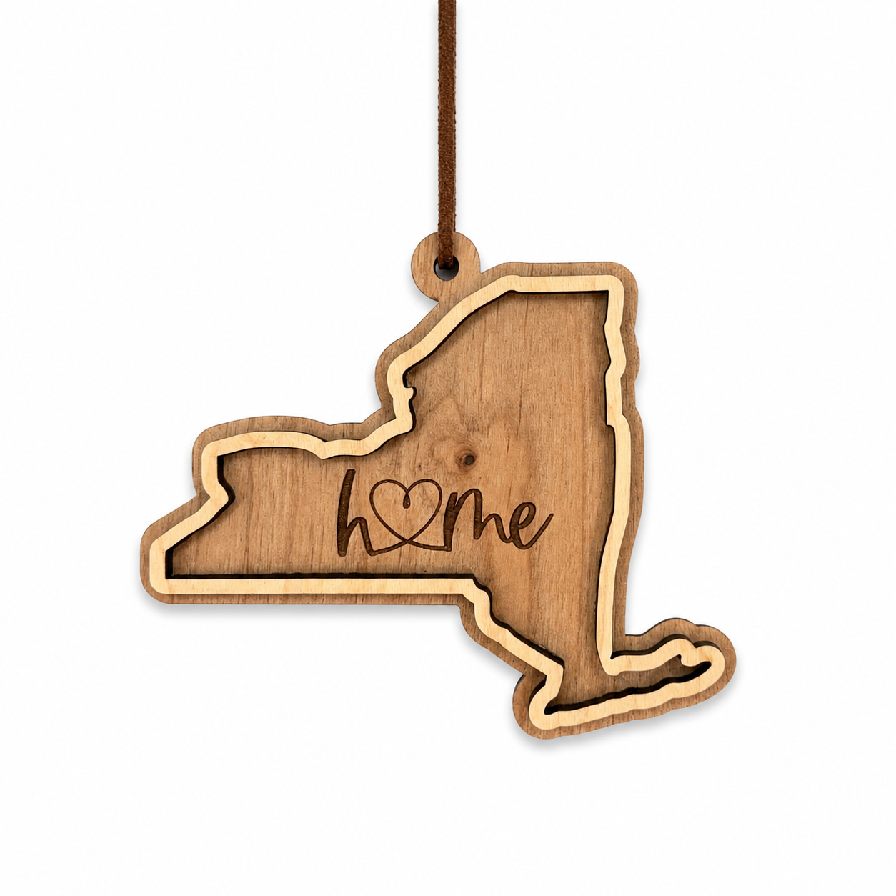 Layered New York wood ornament with engraved “home” script and faux leather cord on white background.
