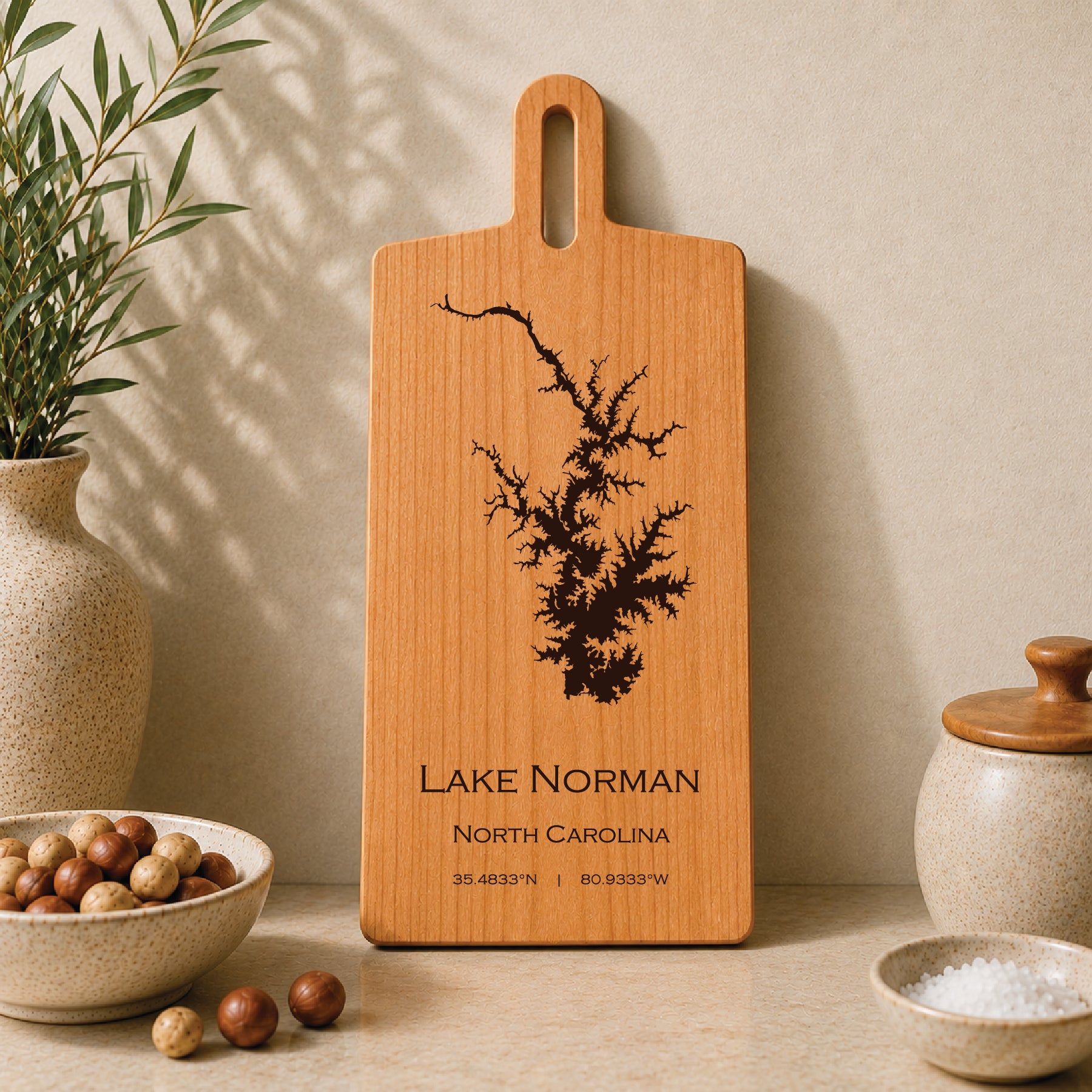 Lake Norman engraved serving board displayed on a neutral kitchen countertop with ceramic decor