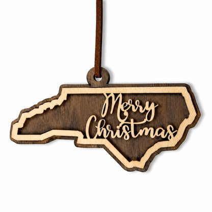 Wooden ornament shaped like North Carolina with 'Merry Christmas' text on a white background