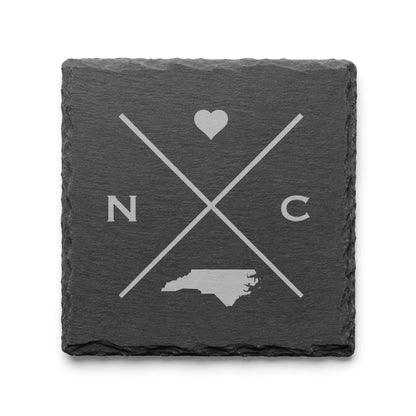 Engraved North Carolina slate coaster featuring a minimalist crossed-line design with heart detail and North Carolina silhouette on a clean light background.