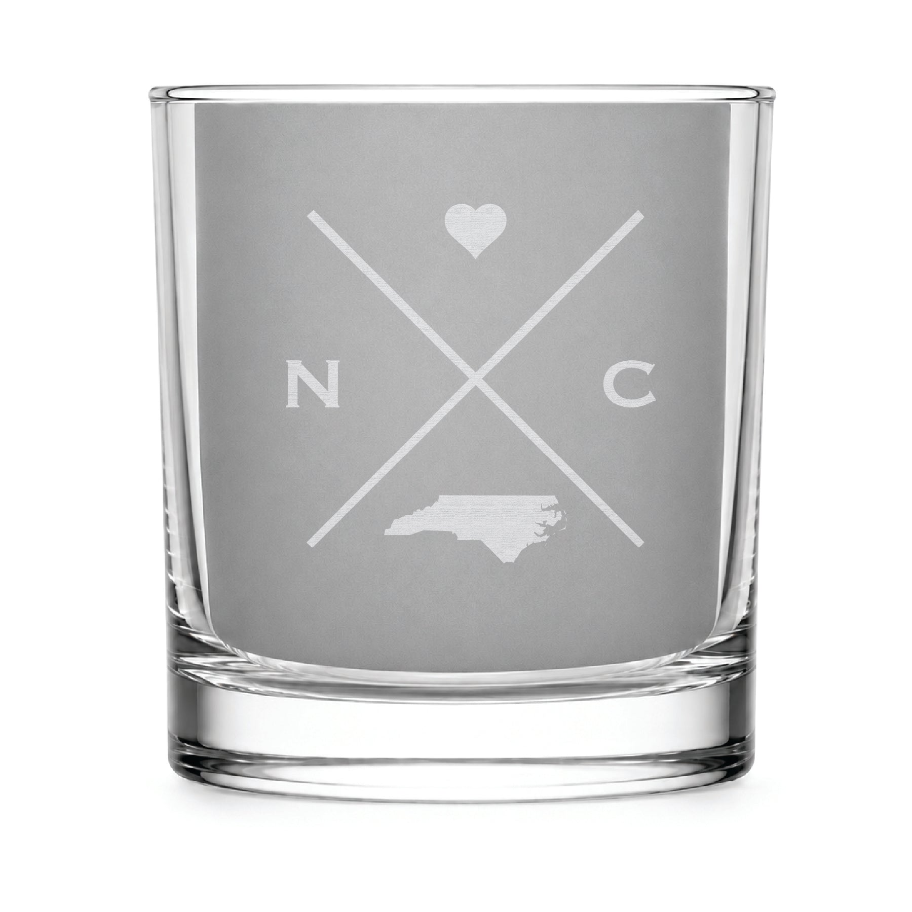Clear engraved rocks glass featuring a minimalist crossed-line North Carolina  design with monogram initials, heart icon, and North Carolina silhouette on a clean light background.