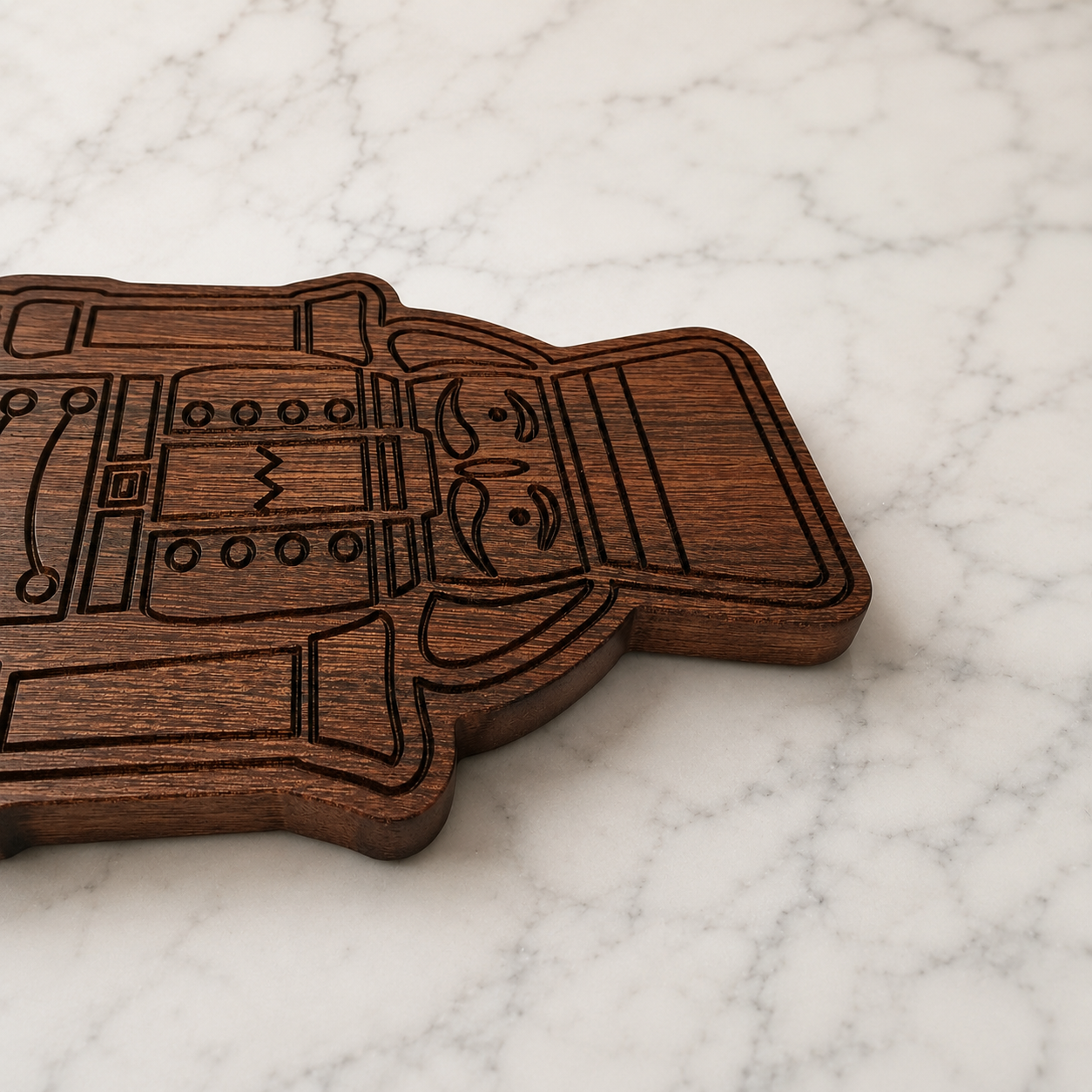 Close-up detail of engraved nutcracker serving board in dark sapele wood on a marble surface