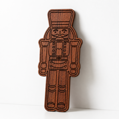 Close-up detail of engraved nutcracker serving board in dark sapele wood on a marble surface