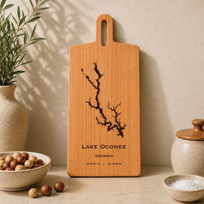 Lake Oconee engraved serving board displayed on a neutral kitchen countertop with ceramic decor