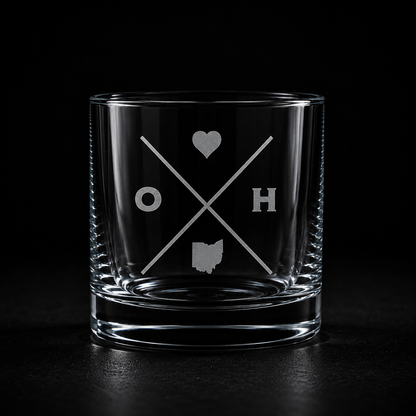 Engraved Ohio rocks glass with frosted Ohio silhouette and crossed-letter monogram on a dark background.