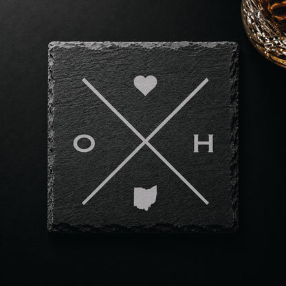 Dark slate coaster with engraved Ohio crossed-line design, heart icon, and Ohio silhouette on a dark background.