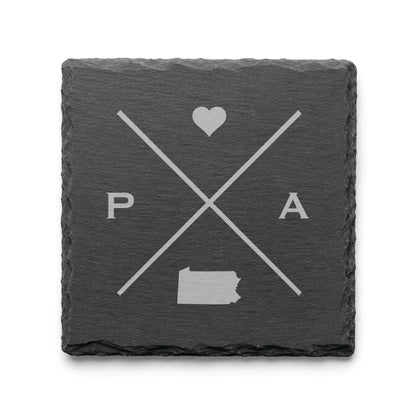 Engraved Pennsylvania slate coaster featuring a minimalist crossed-line design with heart detail and Pennsylvania silhouette on a clean light background.