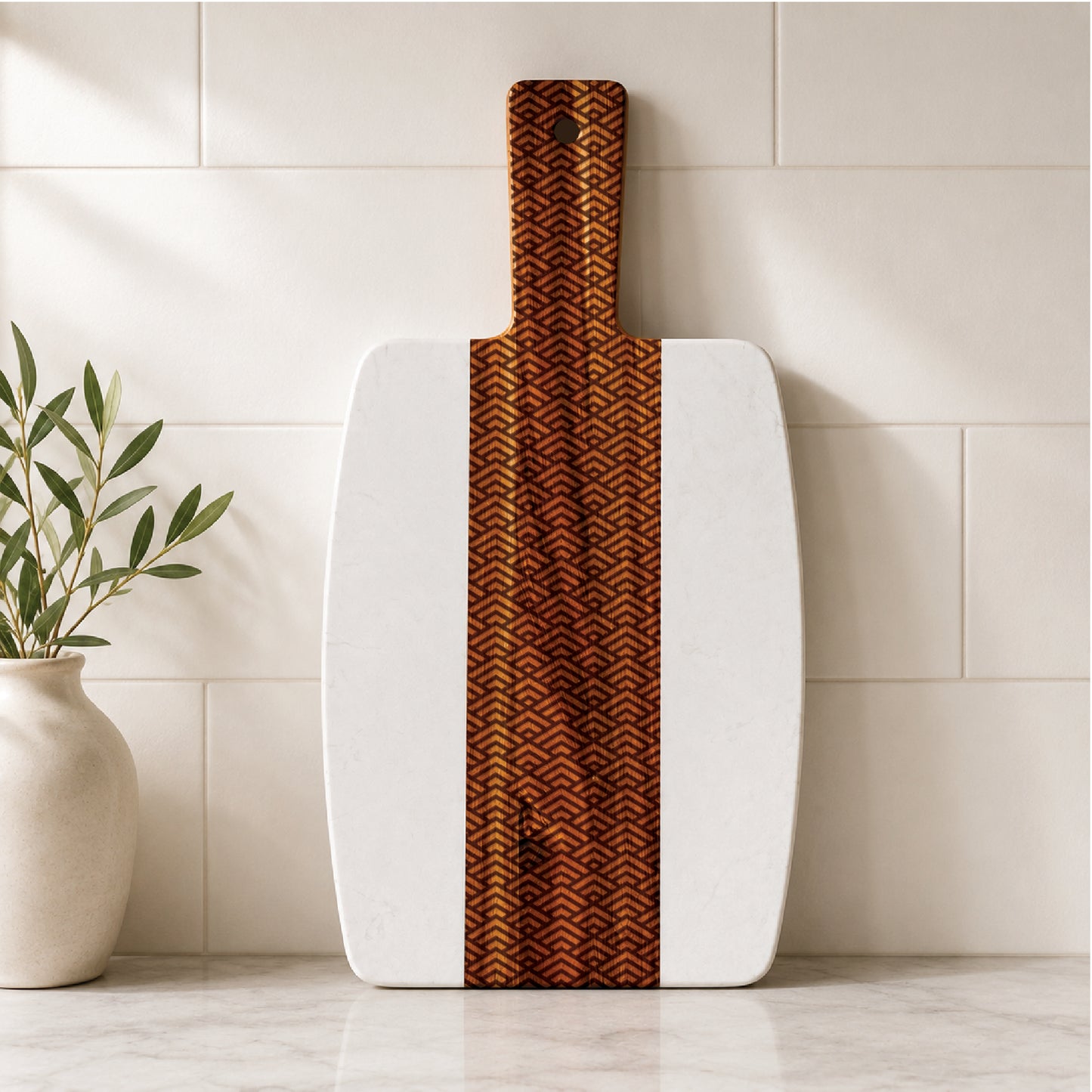 Marble and acacia charcuterie board featuring an engraved geometric peak pattern, displayed upright against a neutral tile backsplash.