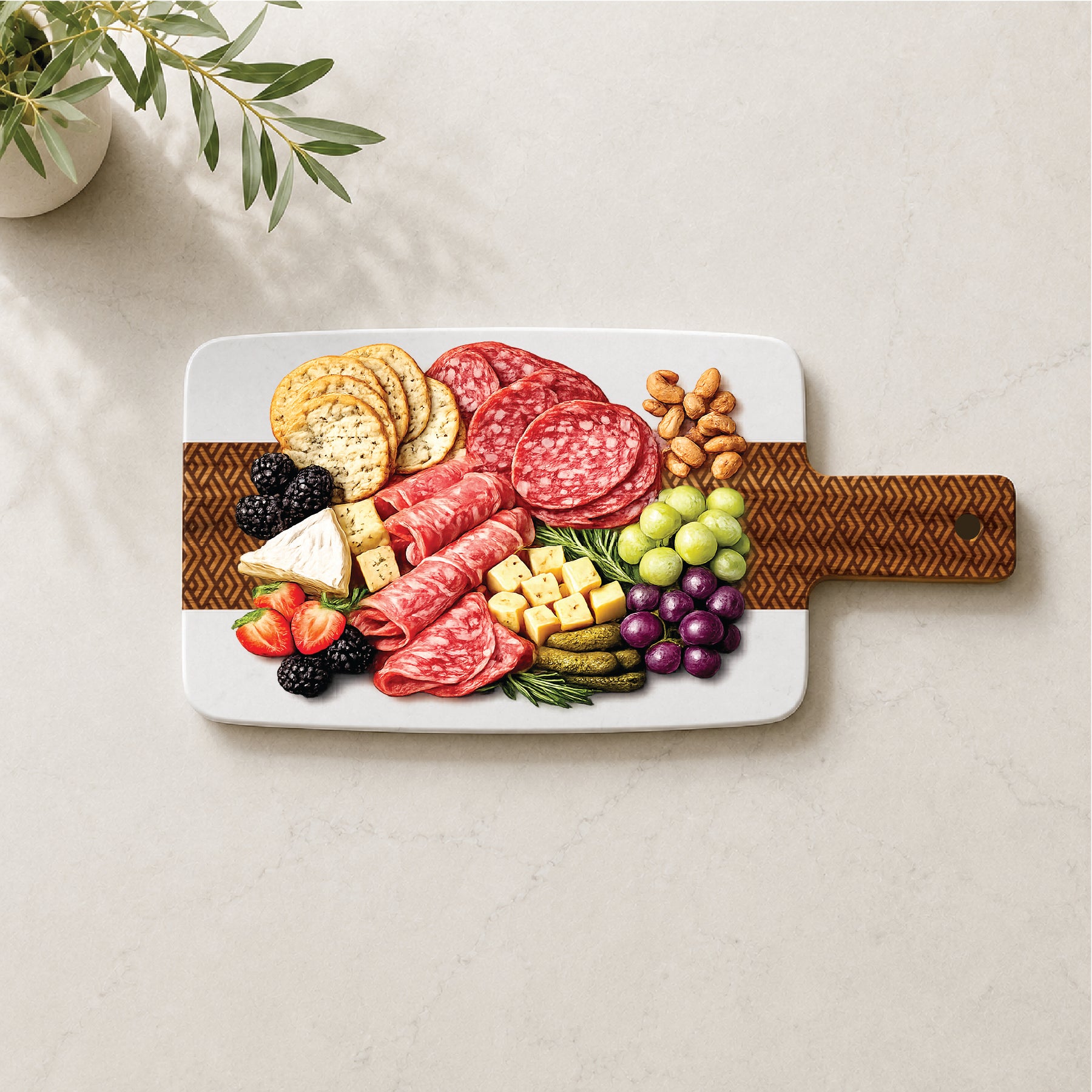 Geometric pattern marble and acacia cheese board styled with charcuterie meats, cheeses, crackers, grapes, berries, and nuts.