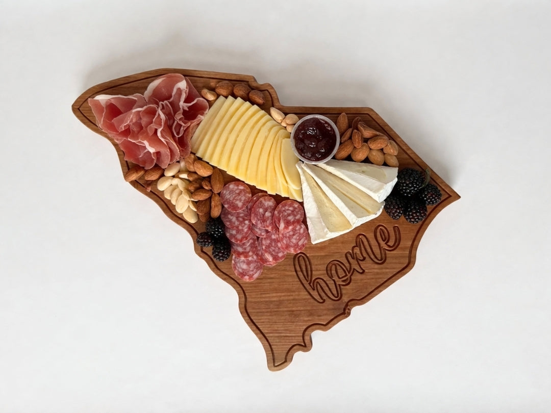 South Carolina shaped wooden serving board styled with charcuterie including cheese, meats, nuts, and fruit