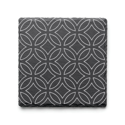 Geometric circle slate coaster with engraved repeating circular pattern on natural black slate background.