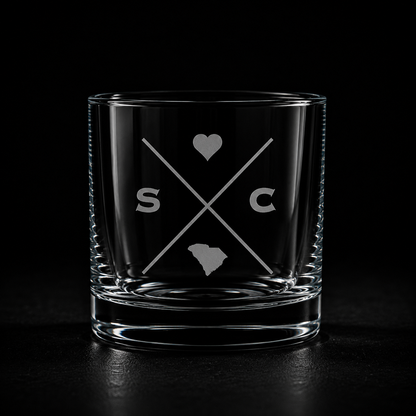 Engraved South Carolina rocks glass with frosted South Carolina silhouette and crossed-letter monogram on a dark background.