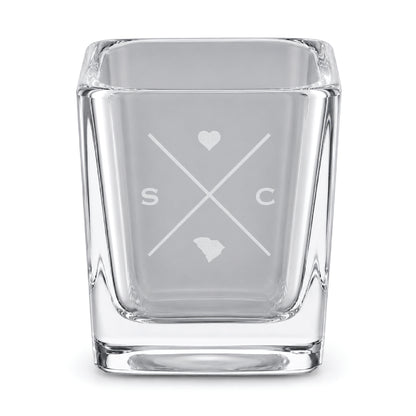Clear engraved South Carolina shot glass featuring a minimalist crossed-line design with heart detail and South Carolina silhouette on a clean light background.