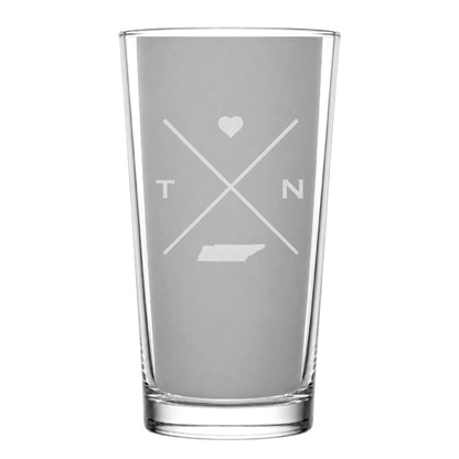Clear pint glass with engraved Tennessee crossed-line design, heart icon, and Tennessee silhouette on a clean light background