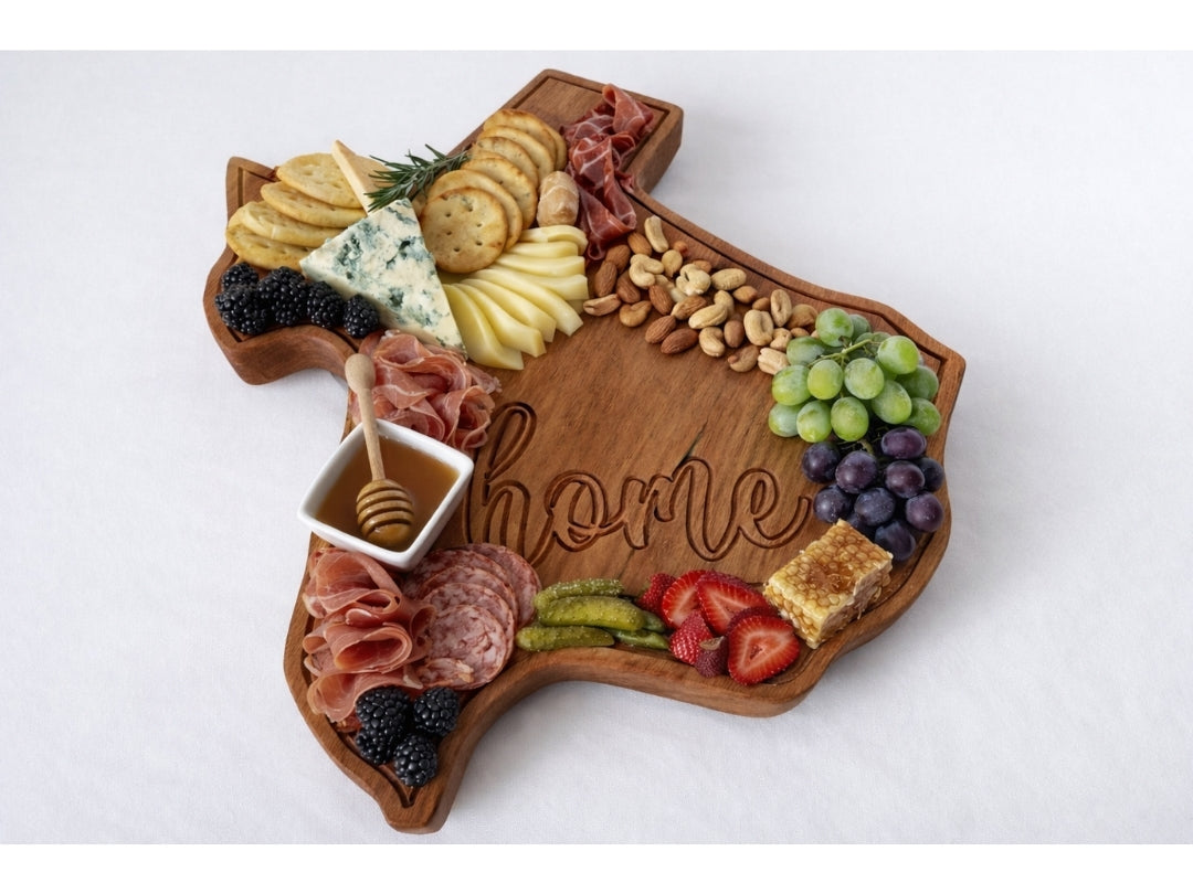 Texas shaped wooden serving board styled with charcuterie including cheese, meats, nuts, and fruit